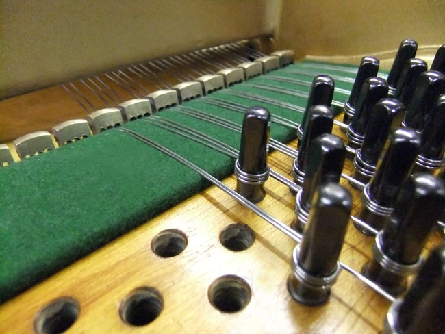 Inserting tuning pins and restringing grand piano - detail